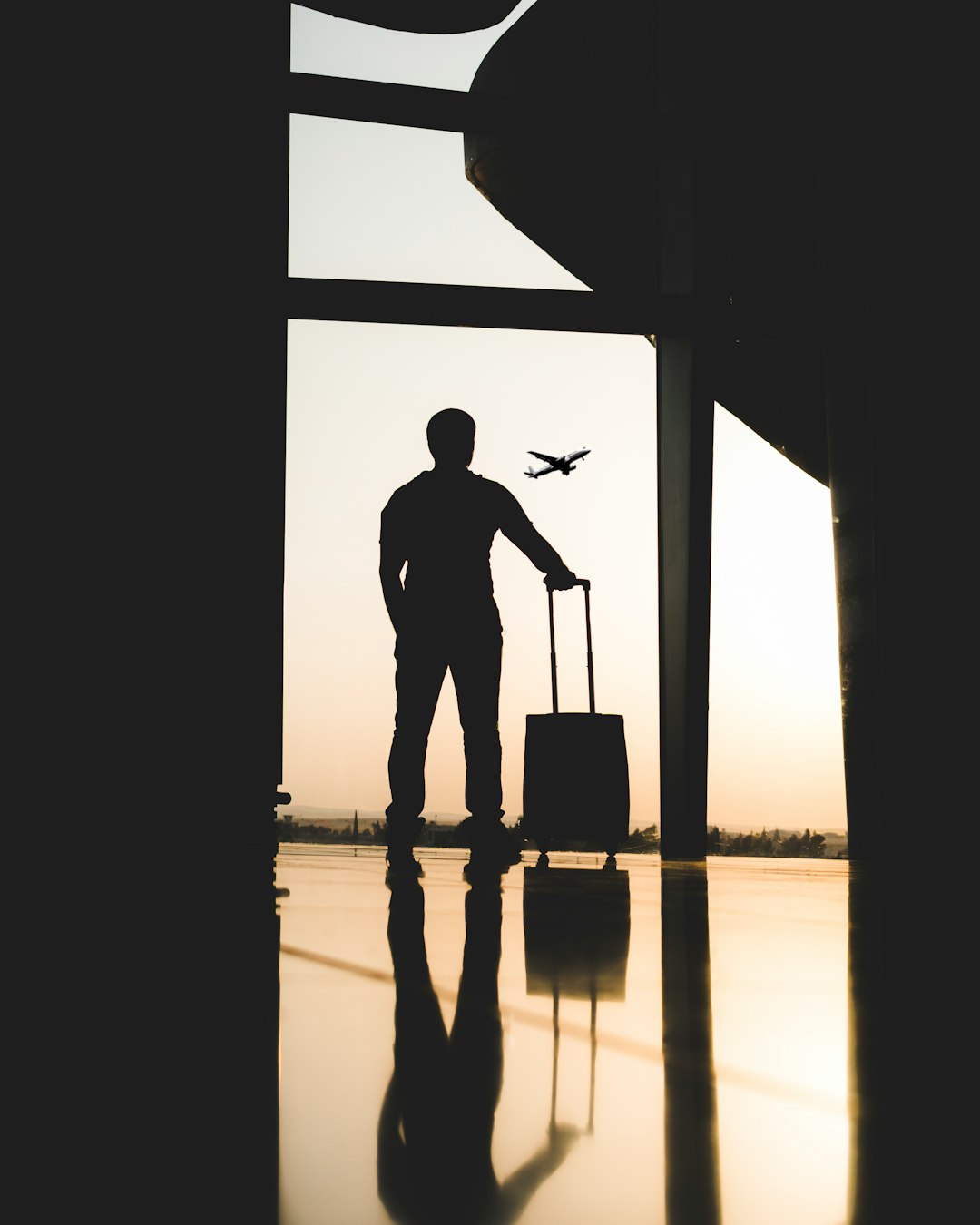 silhouette-of-man-holding-luggage-inside-airport-bmilykzhkmy